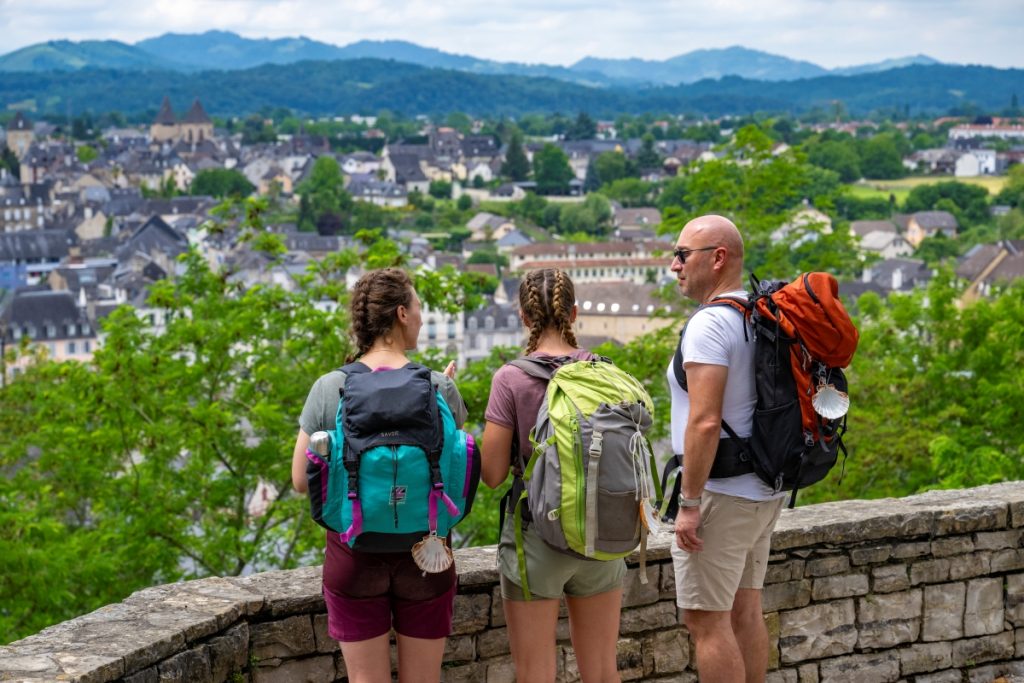 des randonneurs sur le chemin de saint jacques de compostelle admirent la vuer sur oloron sainte marie depuis la voie d'arles GR653