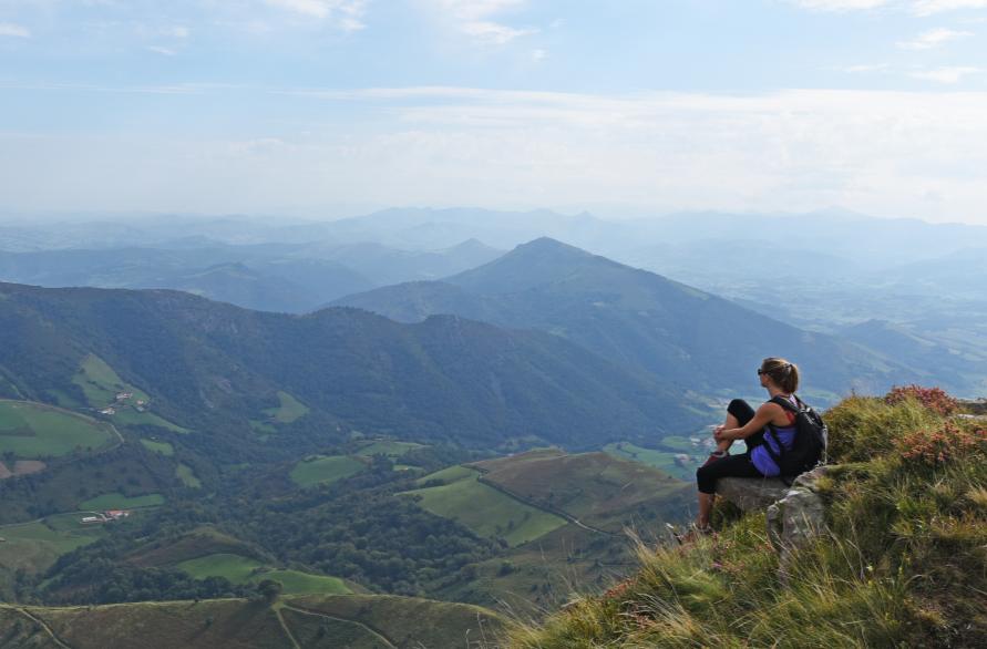 une randonneuse savoure la vue sur les pyrénées en Béarn Pays basque